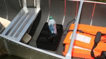 Použití držáku nápojů v malém plavidle. Na obrázku je položen na dně kánoe - s vloženým mobilem i PET 1,5 l lahví.